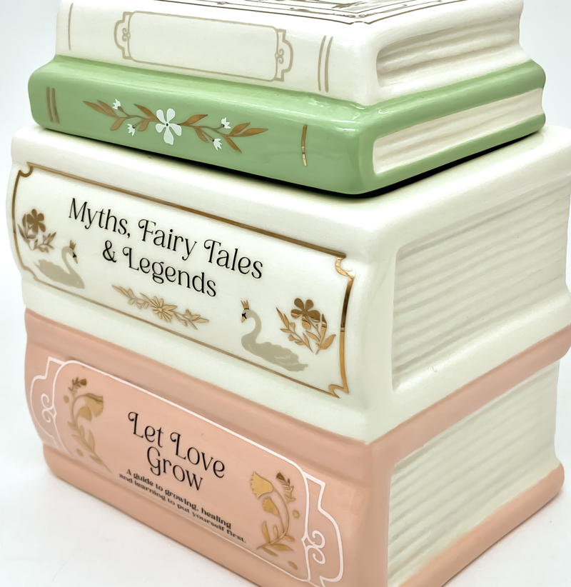 Detalle del quemador de cerámica con diseño de libros apilados en tonos pastel