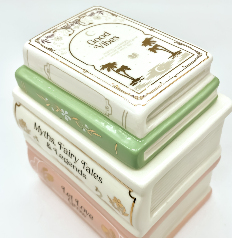 Detalle del quemador de cerámica con diseño de libros apilados en tonos pastel