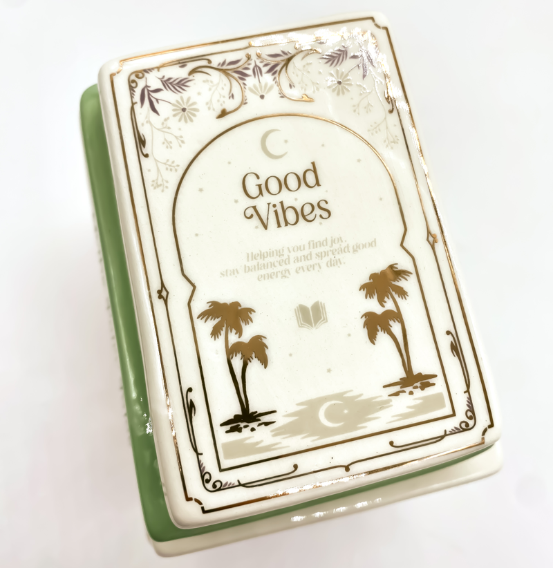 Detalle del quemador de cerámica con diseño de libros apilados en tonos pastel