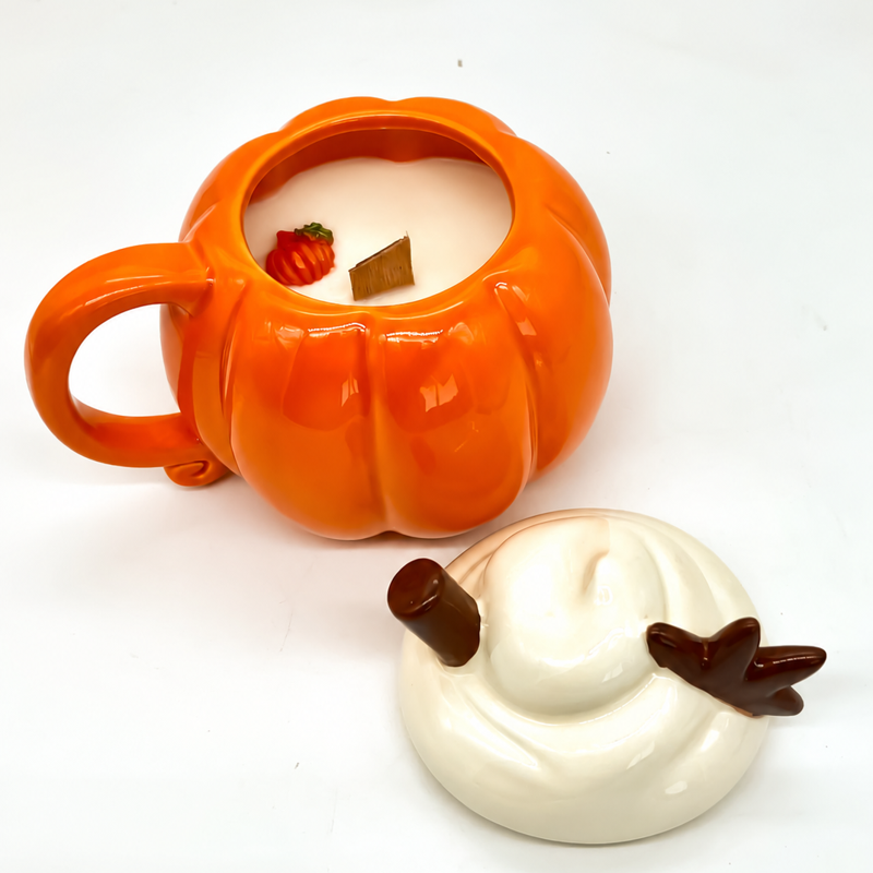 Vela aromática en taza de calabaza con tapa colocada a un lado