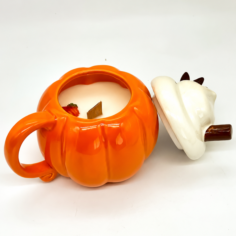 Vela aromática en taza de calabaza con tapa colocada a un lado