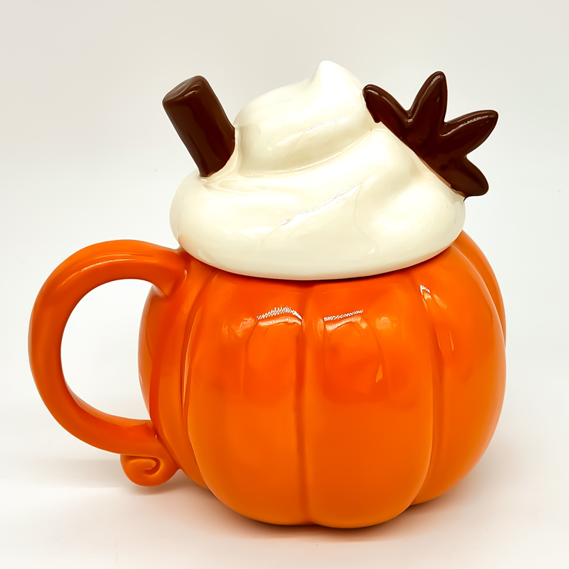 Vela aromática en taza de cerámica naranja con forma de calabaza y tapa decorativa blanca