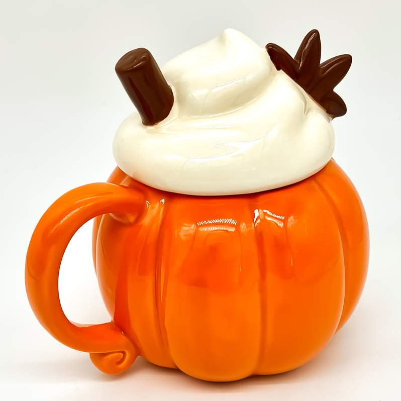 Vela aromática en taza de cerámica naranja con forma de calabaza y tapa decorativa blanca